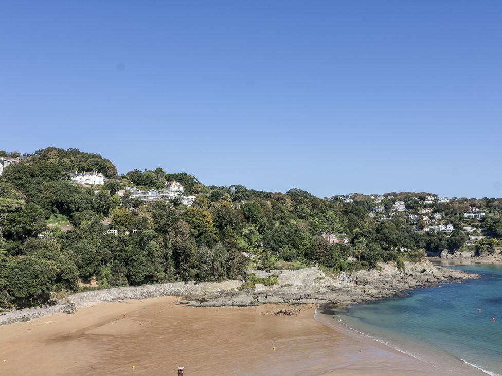 A beach with trees and houses along the coastline at 19 Bolt Head Salcombe