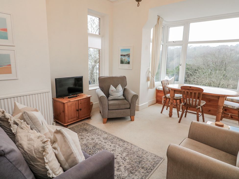 A living room with a television and dining table at 1 Hazeldene in Salcombe