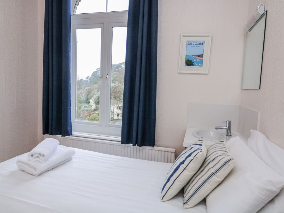 A bedroom with a bed and a window at 1 Hazeldene, Salcombe