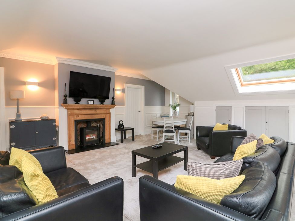 A living room with a fireplace and seating area at The Old Coach House in Dartmouth