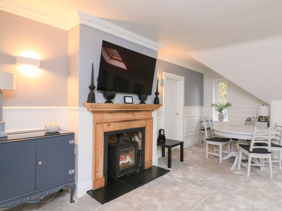 A living room with a fireplace and television at 1 The Old Coach House in Dartmouth