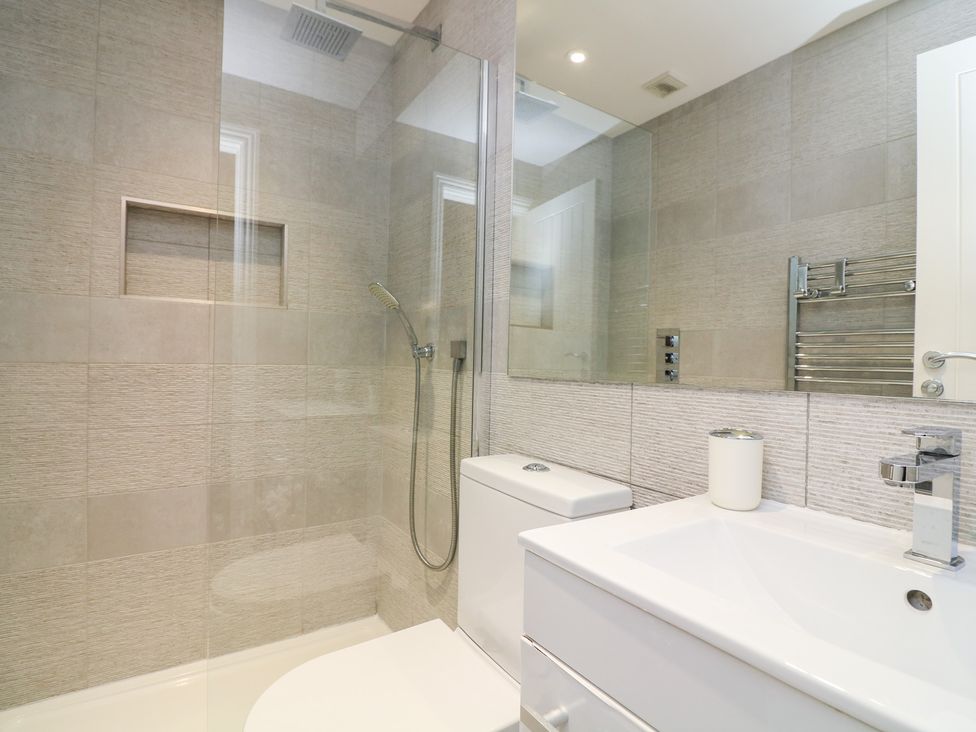 A bathroom with a shower, toilet and sink at 1 The Old Coach House in Dartmouth