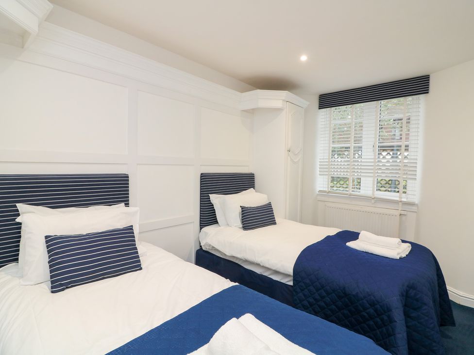 A bedroom with two single beds at 1 The Old Coach House Dartmouth
