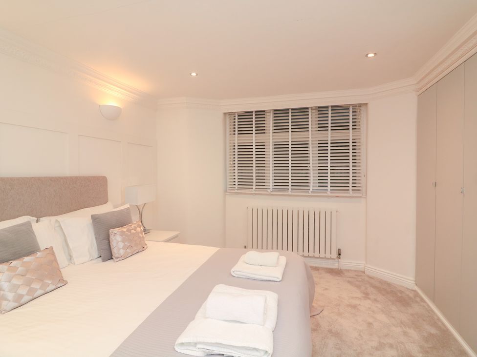 A bedroom with a bed and radiator at 1 The Old Coach House in Dartmouth