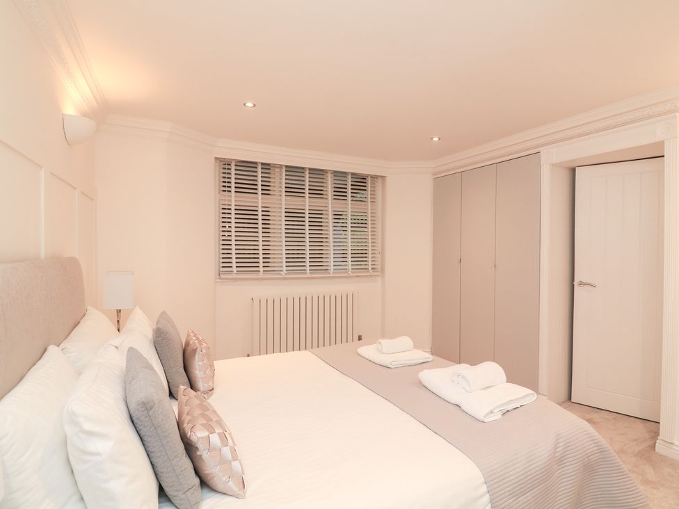 A bedroom with a bed and cabinet at 1 The Old Coach House in Dartmouth