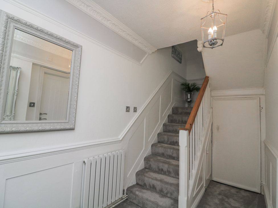 A hallway with stairs and a mirror at 1 The Old Coach House Dartmouth