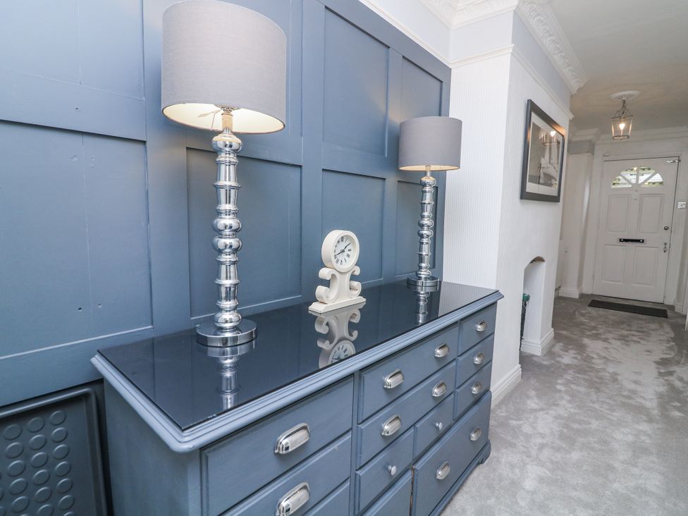 A hallway with a dresser, lamps, and a clock at 1 The Old Coach House Dartmoor