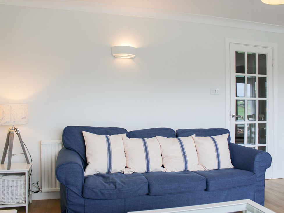 A living room with a blue sofa and cushions at 2 Poundstone Court in Salcombe