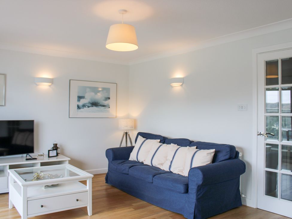 A living room with a blue sofa and a coffee table at 2 Poundstone Court in Salcombe