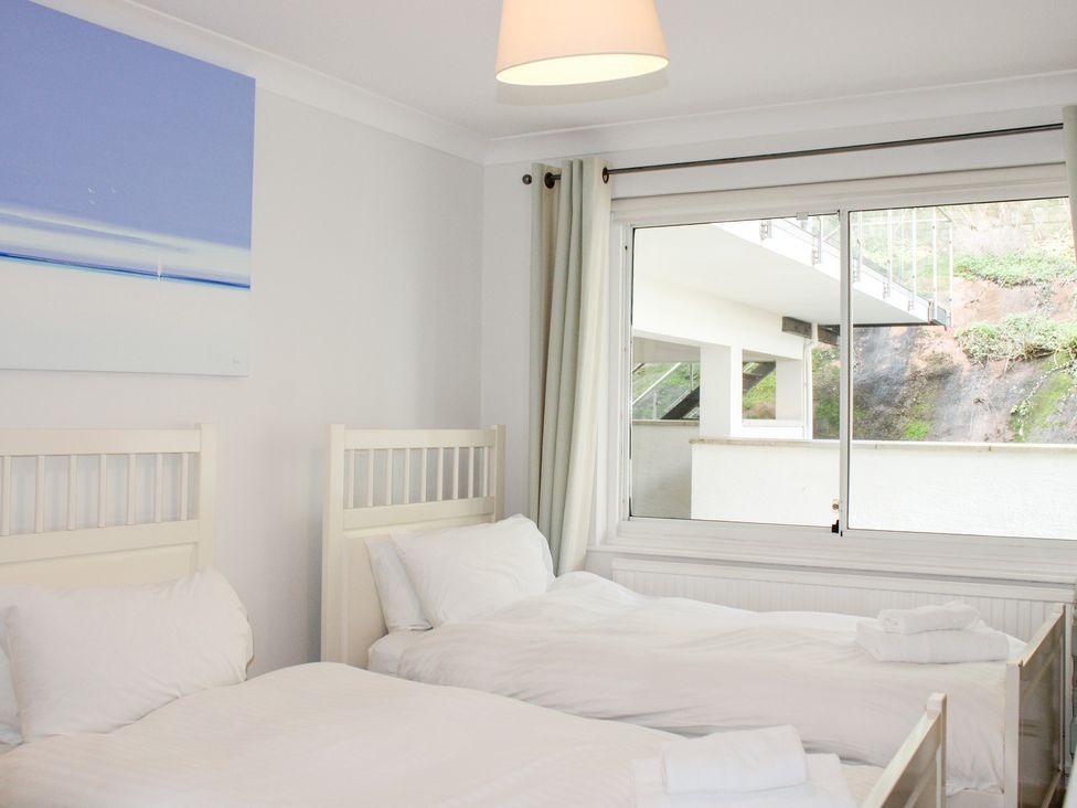 A bedroom with two beds and a window at 2 Poundstone Court in Salcombe