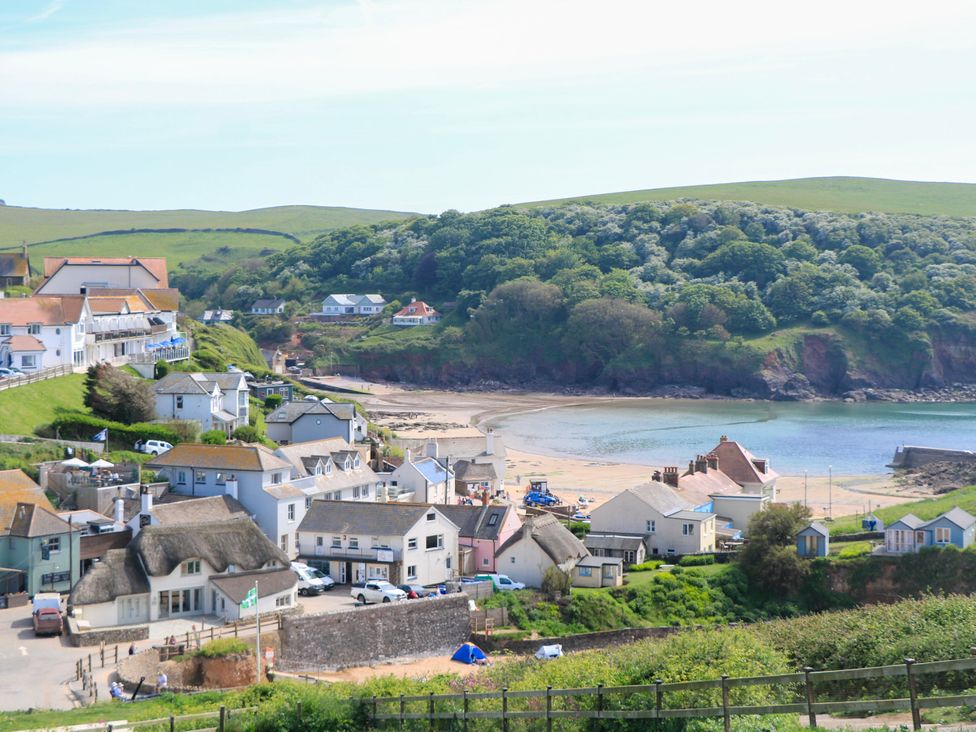 A coastal village with houses near a beach and hills in the background at 2 Sea Gardens in Hope Cove