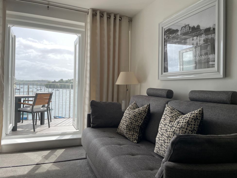 A living room with a sofa and balcony view at 35 The Salcombe in Salcombe