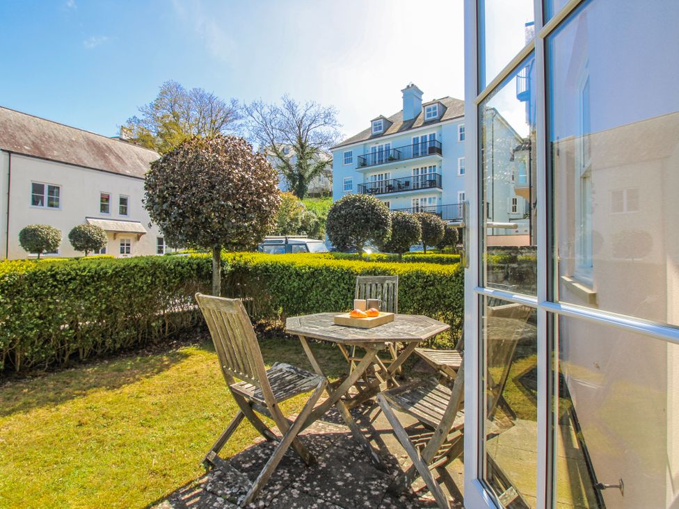 A garden with a table and chairs at 3 Combehaven Salcombe