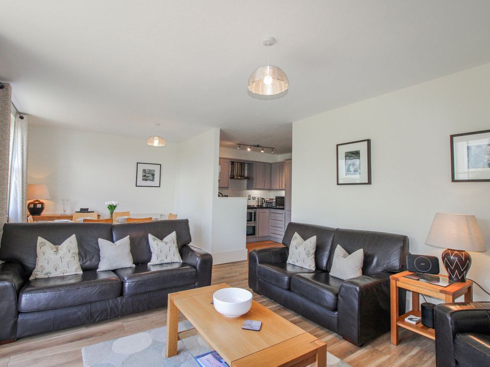 A living room with a sofa and coffee table at 3 Combehaven in Salcombe