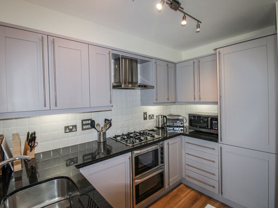 A kitchen with cabinets, oven, stove, sink and appliances at 3 Combehaven Salcombe