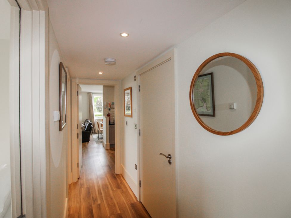 A hallway with a mirror and framed pictures at 3 Combehaven Salcombe