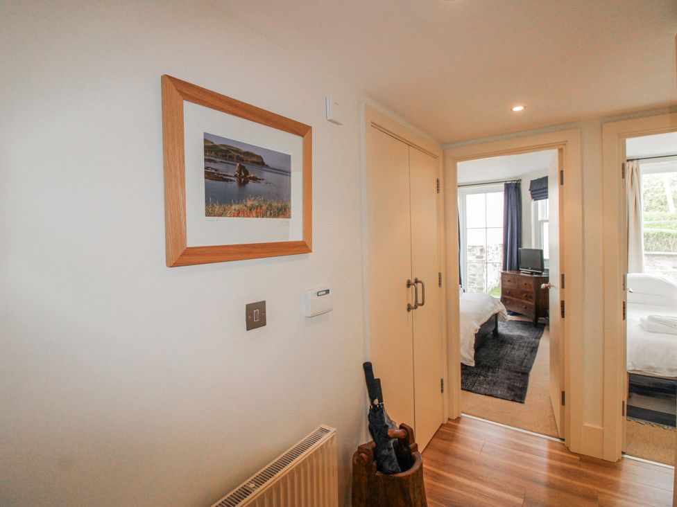 A hallway with a picture frame and view of bedrooms at 3 Combehaven Salcombe