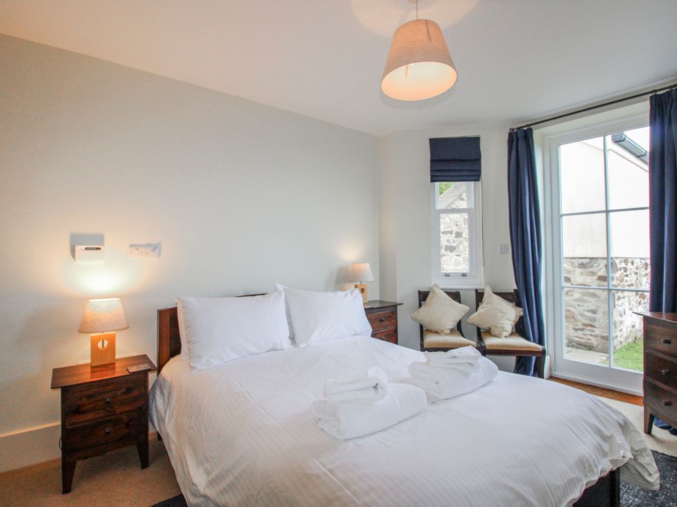 A bedroom with a bed and nightstand at 3 Combehaven in Salcombe