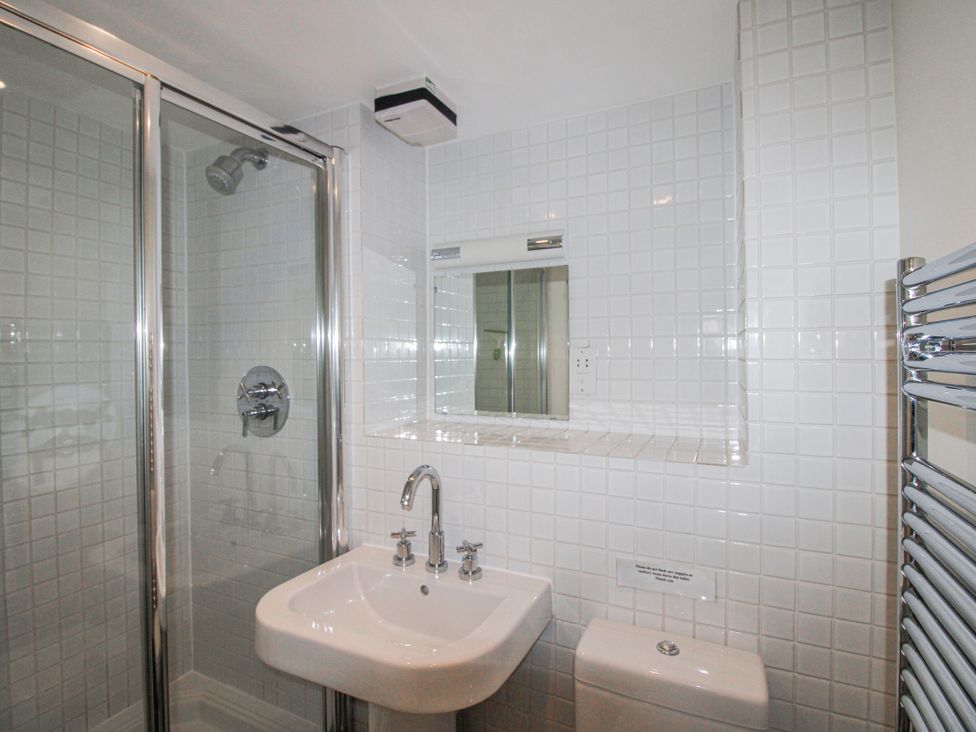 A bathroom with a shower, sink, and toilet at 3 Combehaven in Salcombe