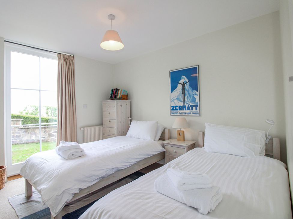 A bedroom with two beds and a window at 3 Combehaven in Salcombe