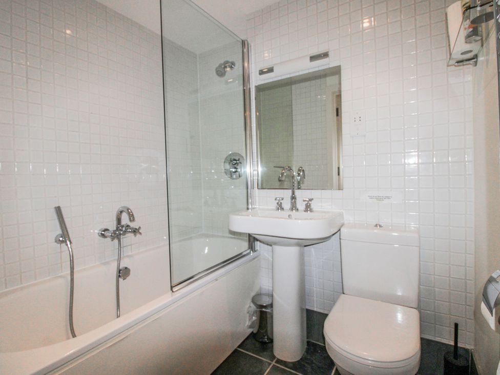 A bathroom with a bathtub, shower, basin, and toilet at 3 Combehaven Salcombe