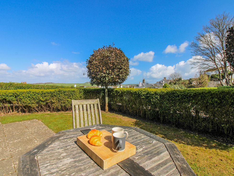 A table with croissants and a cup in the garden at 3 Combehaven Salcombe
