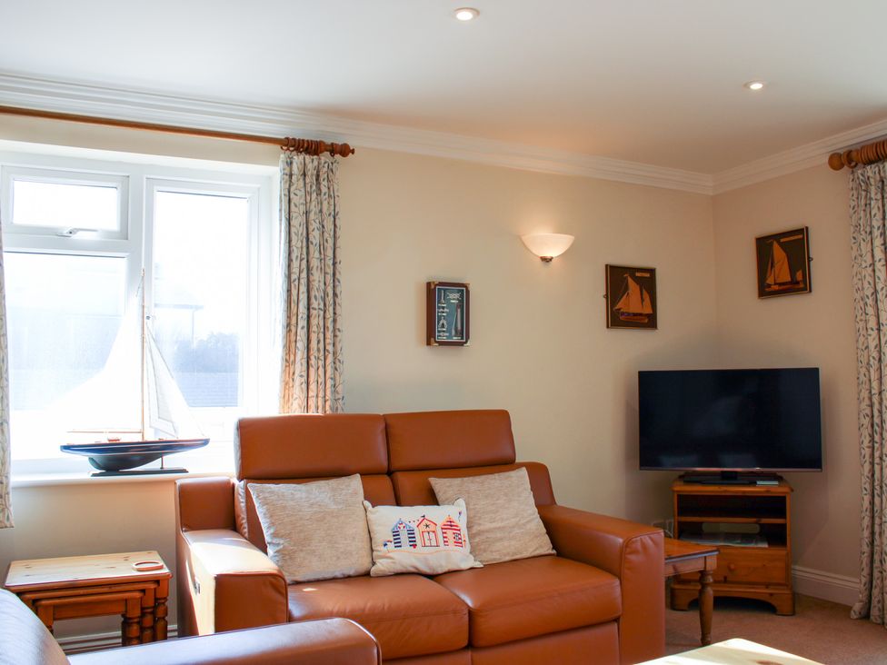 A living room with a sofa and television at 3 Thurlestone Rock in Thurlestone
