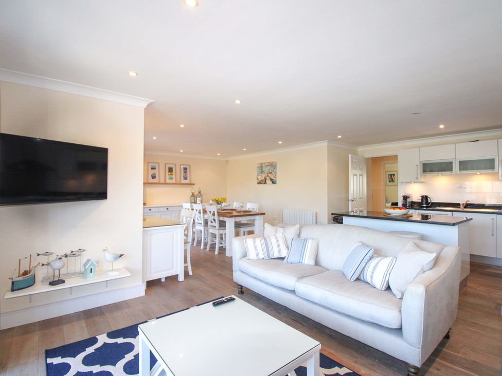A living room with a sofa and dining area at 4 Bolt Head Salcombe