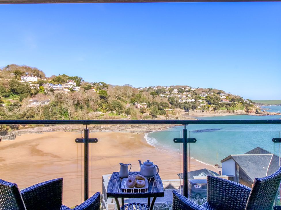 A balcony with a teapot and pastries overlooking the beach at 4 Bolt Head Salcombe