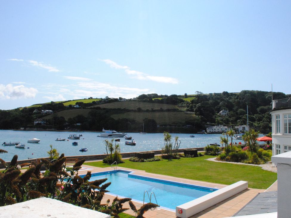 An outdoor area with a swimming pool and boats in the water at 4 The Salcombe in Salcombe