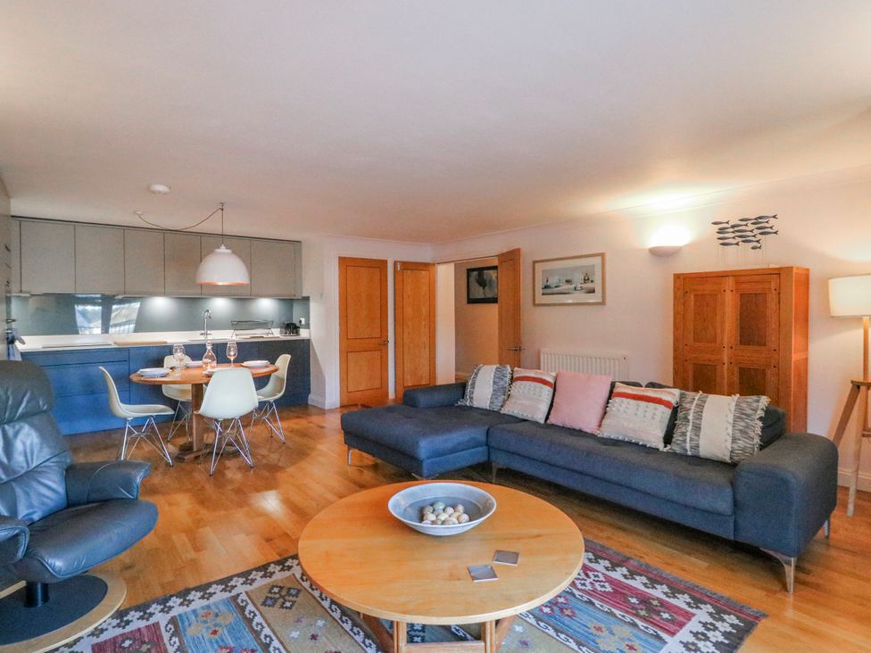 A living room with a sofa, table, and kitchen in 5 Dartmouth House Dartmouth