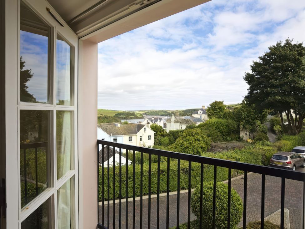 A view from a balcony showing houses and trees at 6 Combehaven Salcombe