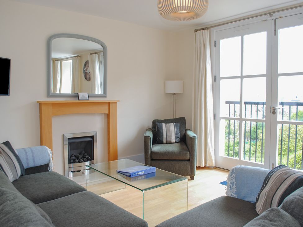 A living room with a sofa and coffee table at 6 Combehaven, Salcombe