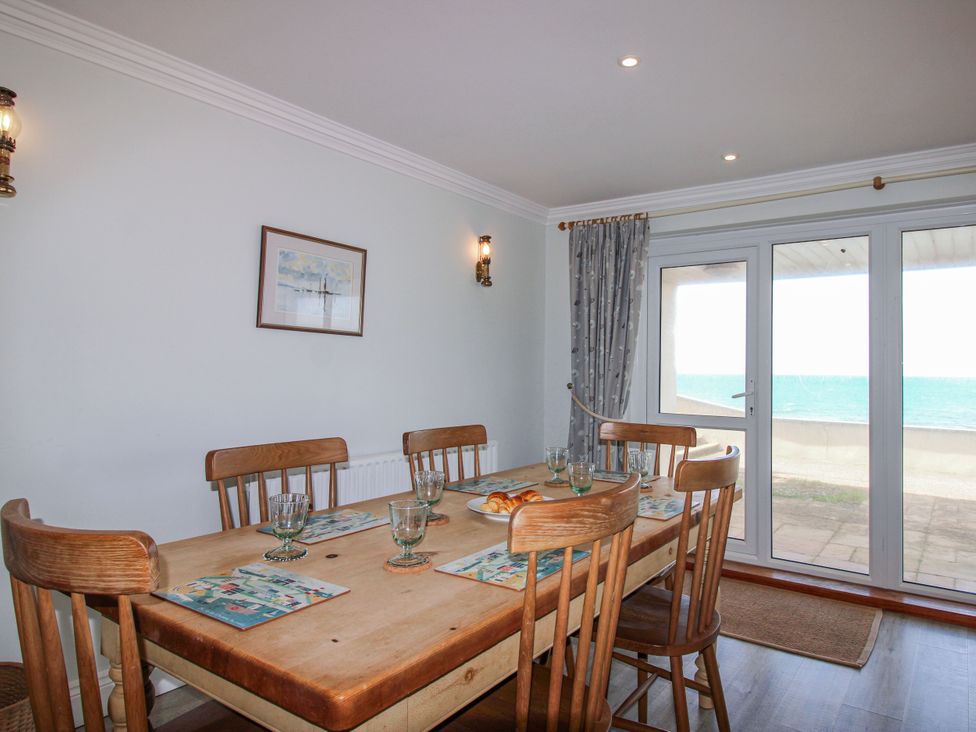 A dining room with a table and chairs at 7 Thurlestone Rock in Thurlestone