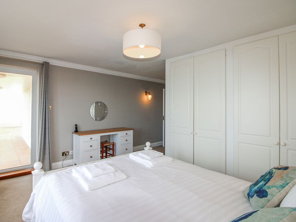 A bedroom with a bed and dresser at 7 Thurlestone Rock in Thurlestone