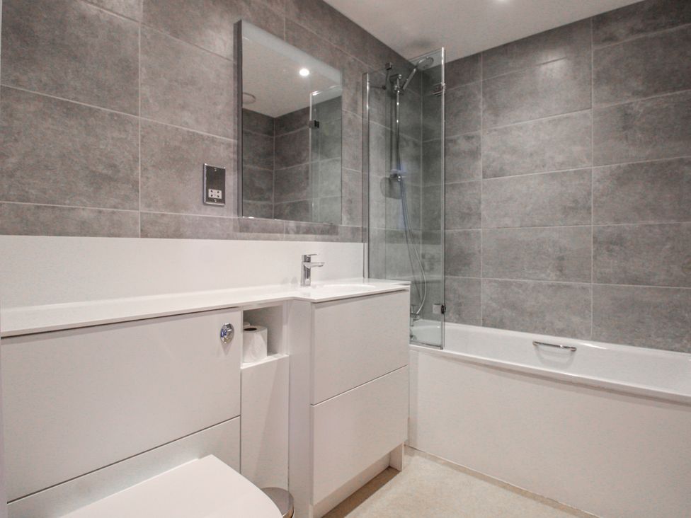 A bathroom with a sink, toilet, bath, and shower at 7 Thurlestone Rock in Thurlestone