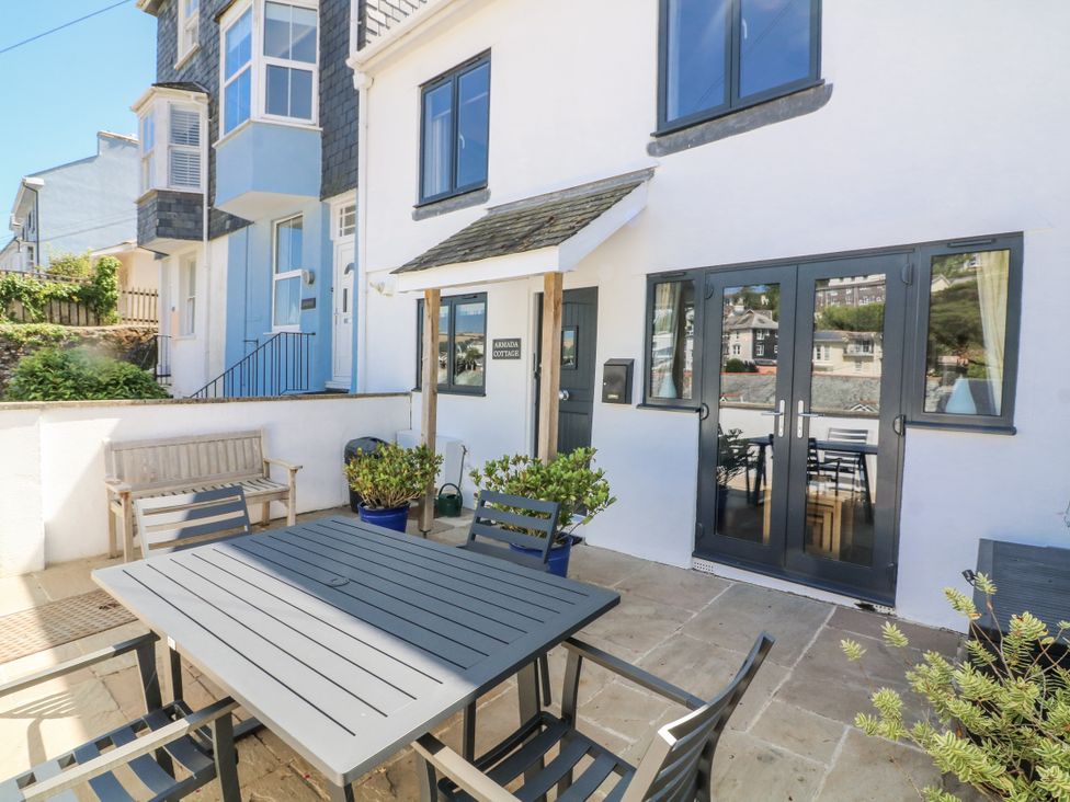 An outdoor seating area with a table and chairs at Armada Cottage Dartmouth
