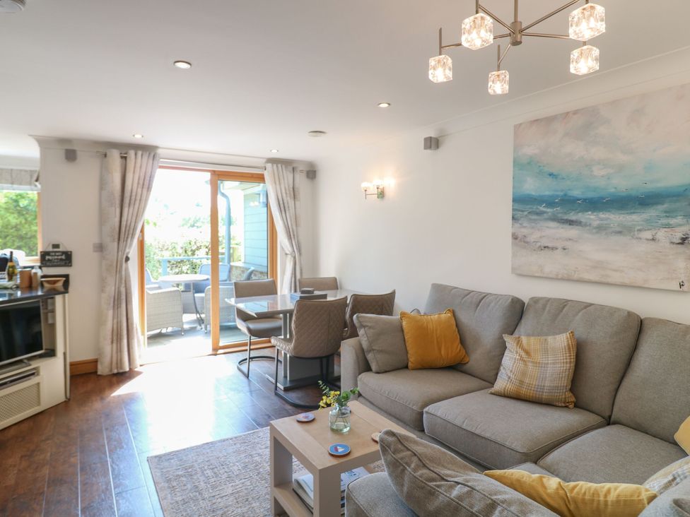 A living room with a sofa and a dining table at 6 Court Cottage, Hillfield Village Dartmouth