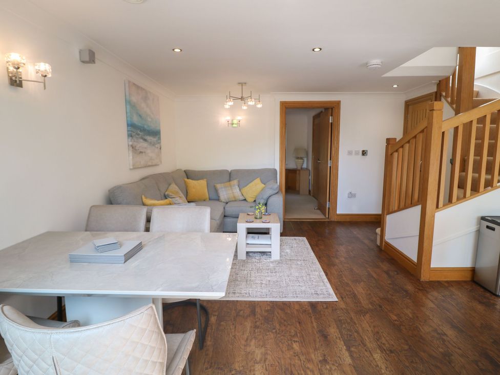 A living room with a sofa and dining table at 6 Court Cottage, Hillfield Village Dartmouth