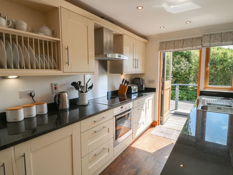 A kitchen with cabinets and appliances at 6 Court Cottage, Hillfield Village Dartmouth