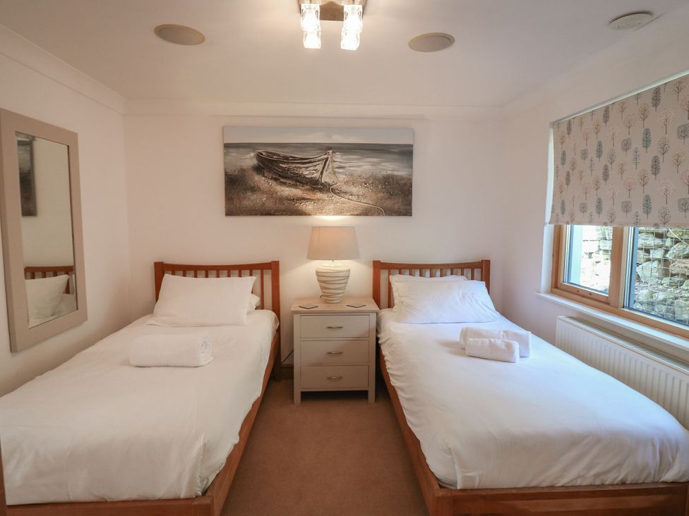 A bedroom with two single beds and a lamp at 6 Court Cottage, Hillfield Village Dartmouth