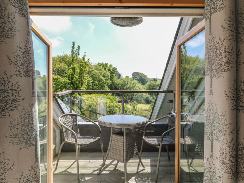A balcony with table and chairs at 6 Court Cottage, Hillfield Village in Dartmouth