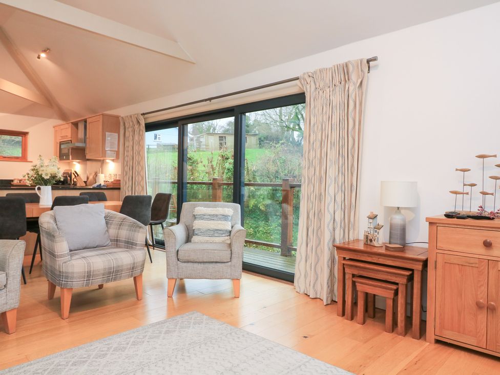 A living room with chairs and a dining table at Courtyard Cottage in Dartmouth