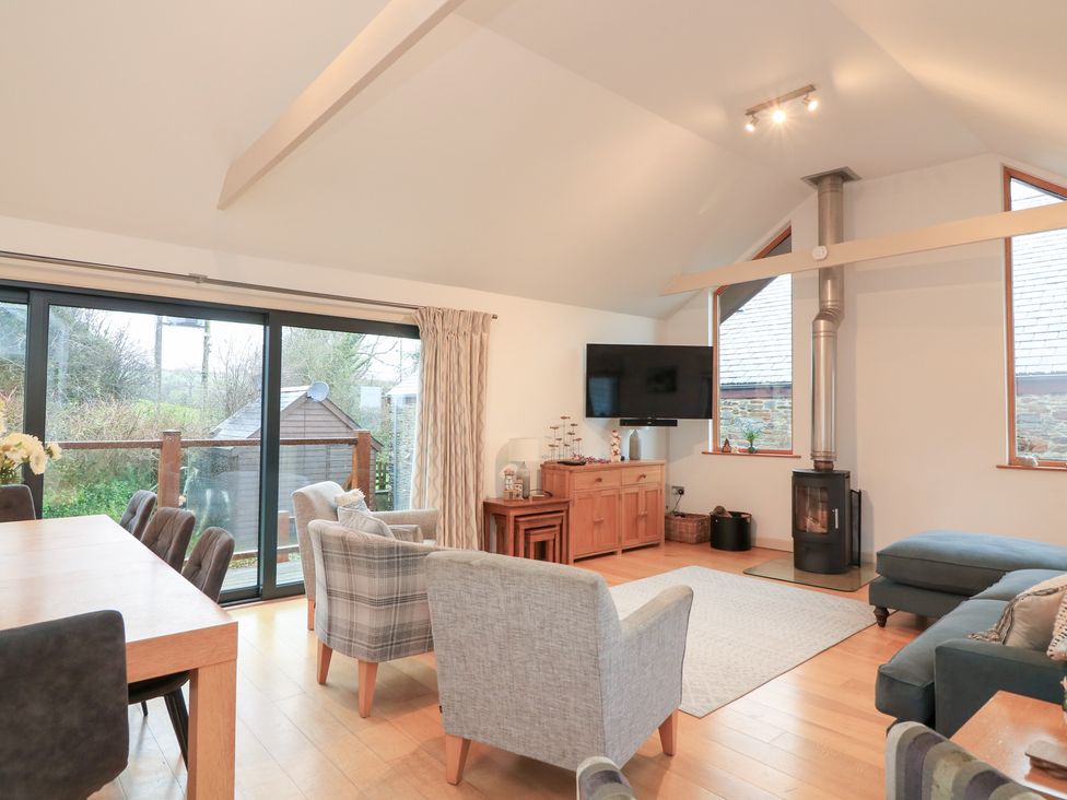 A living room with a dining table and chairs at Courtyard Cottage in Dartmouth
