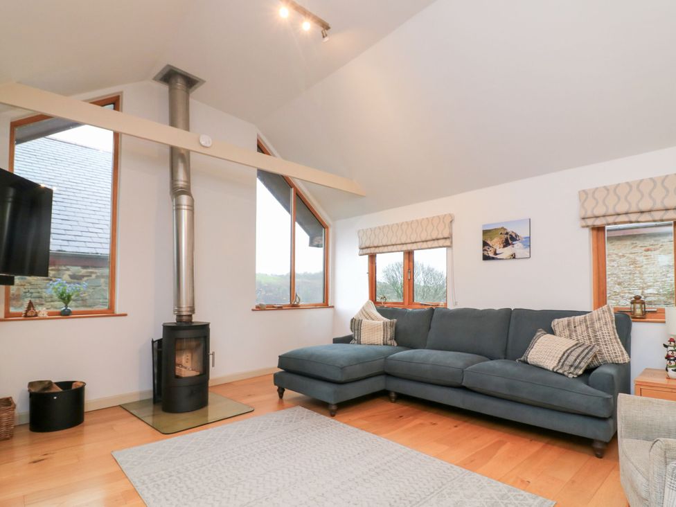 A living room with a sofa and stove at Courtyard Cottage in Dartmouth