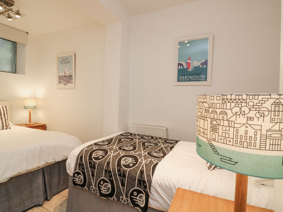 A bedroom with two beds and a lamp at Dart Views in Dartmouth