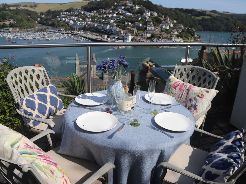 An outdoor dining area with a table set near a waterfront at Dart Views in Dartmouth