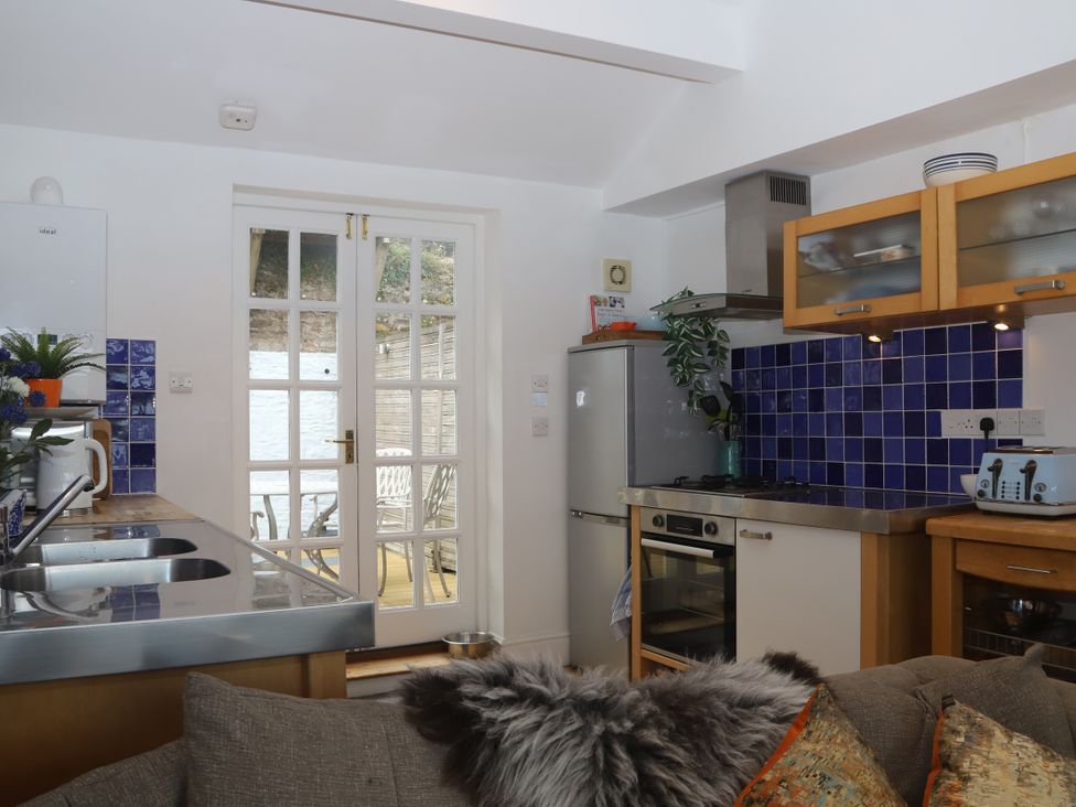 A kitchen with appliances and access to outdoor seating at Dart Views in Dartmouth