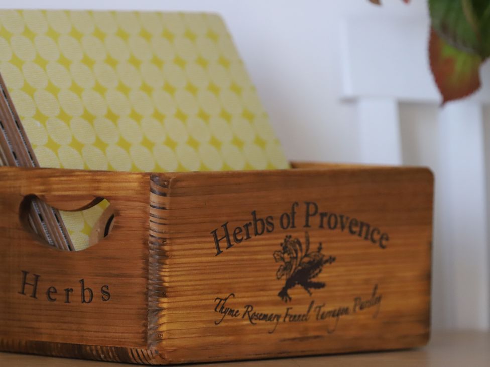 A wooden box labeled Herbs of Provence with yellow papers at Dart Views in Dartmouth