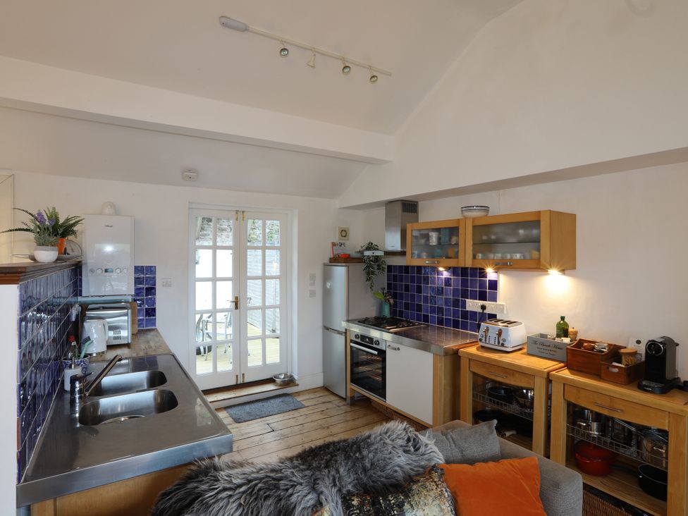 A kitchen with appliances and wooden cabinets at Dart Views Dartmouth